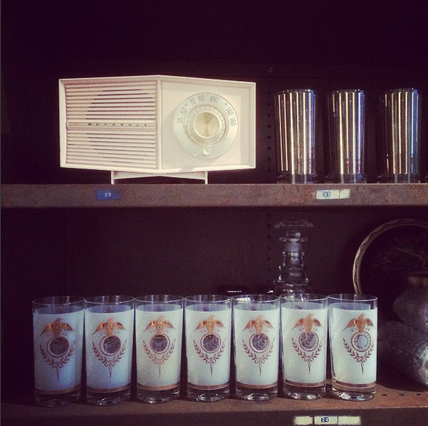 Shelves containing old style radio and drinking glasses